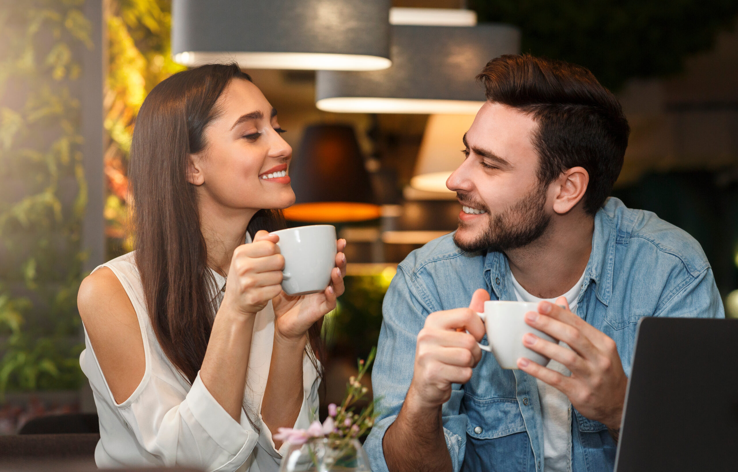 Young couple tasting coffee enjoying flirt and conversation in cafe Dating. Young couple tasting coffee drinks enjoying flirt and conversation during weekend date sitting in cozy cafe